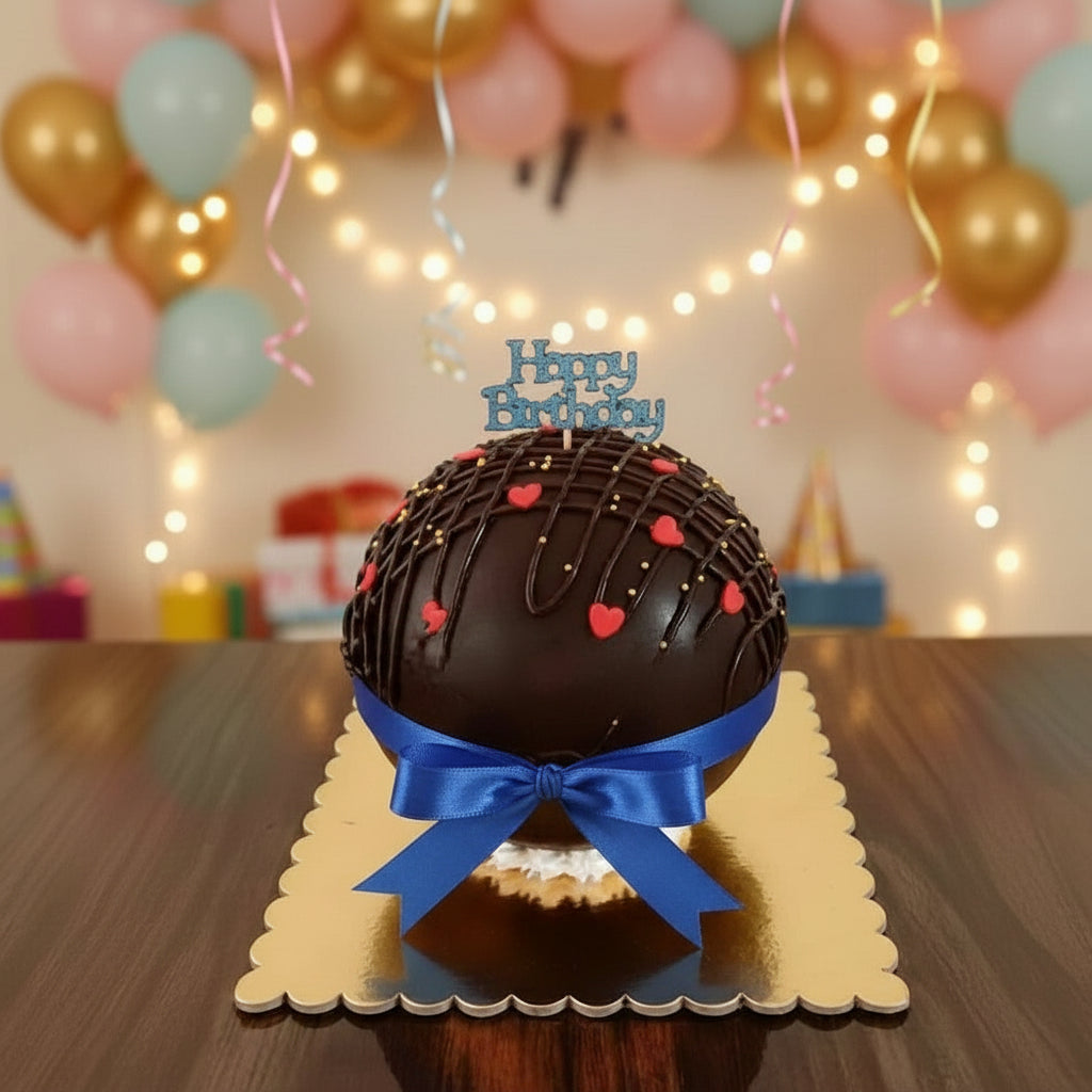 Chocolate birthday cake with a pink bow and 'Happy Birthday' text on a wooden surface.