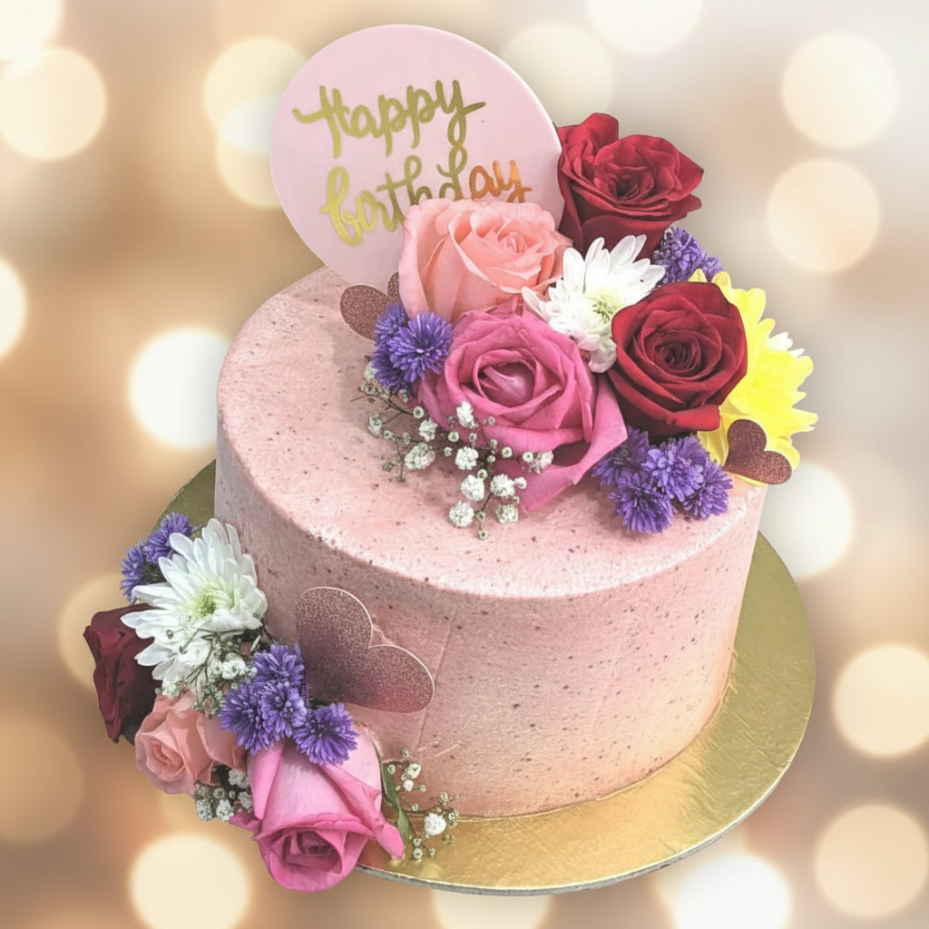 Pink birthday cake with flowers on a marble surface