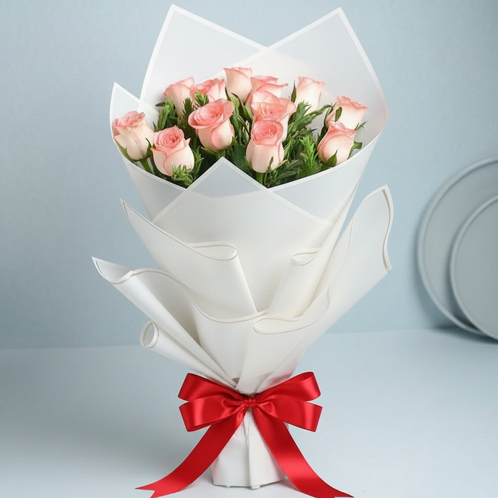 Bouquet of pink roses wrapped in brown paper with a black ribbon on a light pink background